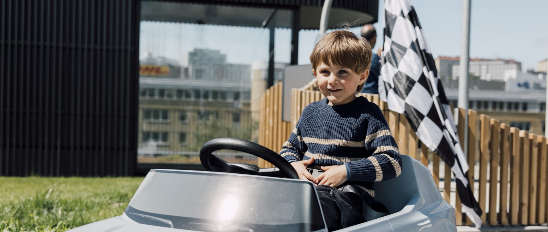 Barn kör blå eldriven Volvo-bil i barnstorlek på Traffic School utomhusbana på World of Volvo i Göteborg.