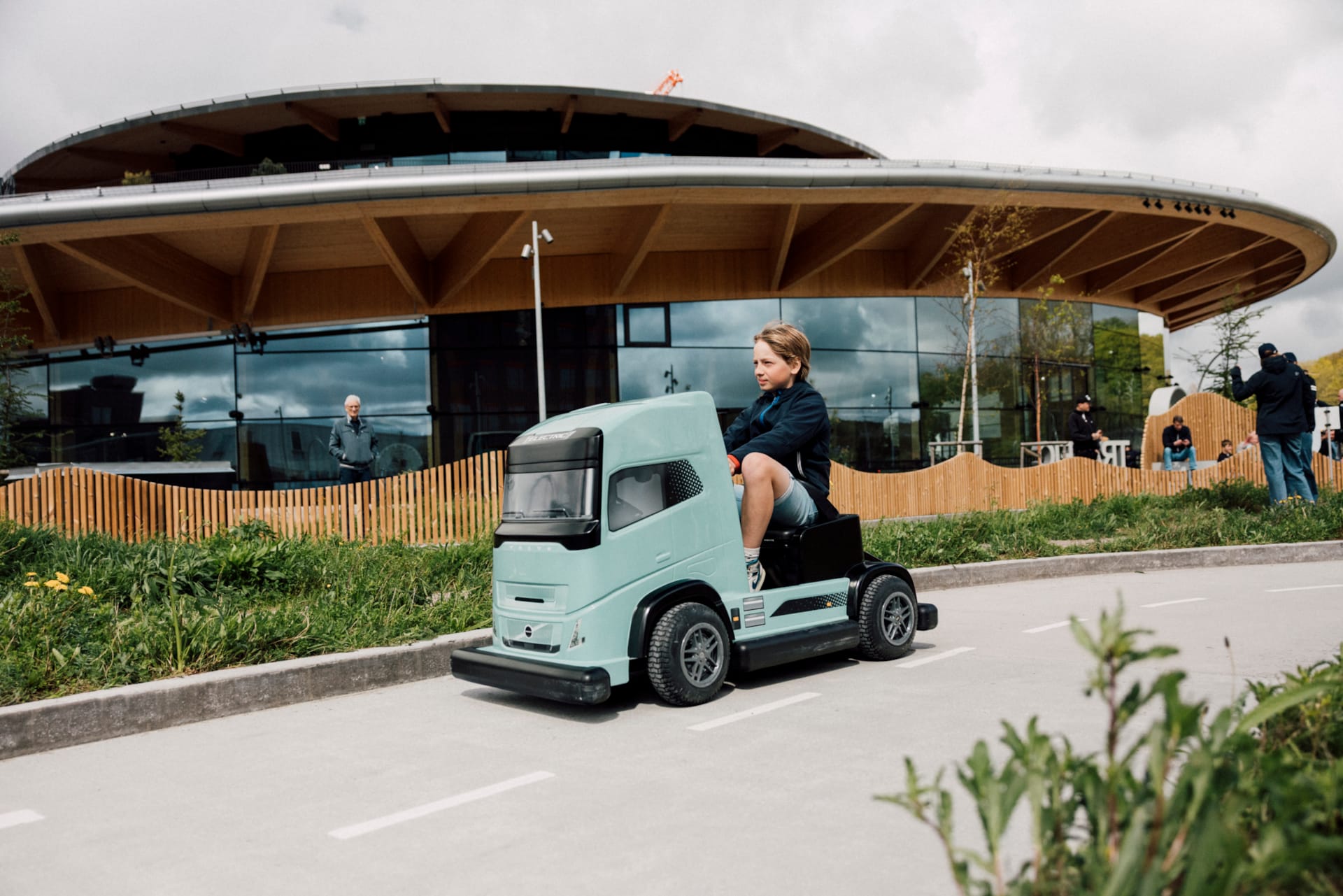 Barn kör eldriven Volvo-lastbil i barnstorlek på Traffic School utomhusbana på World of Volvo i Göteborg.