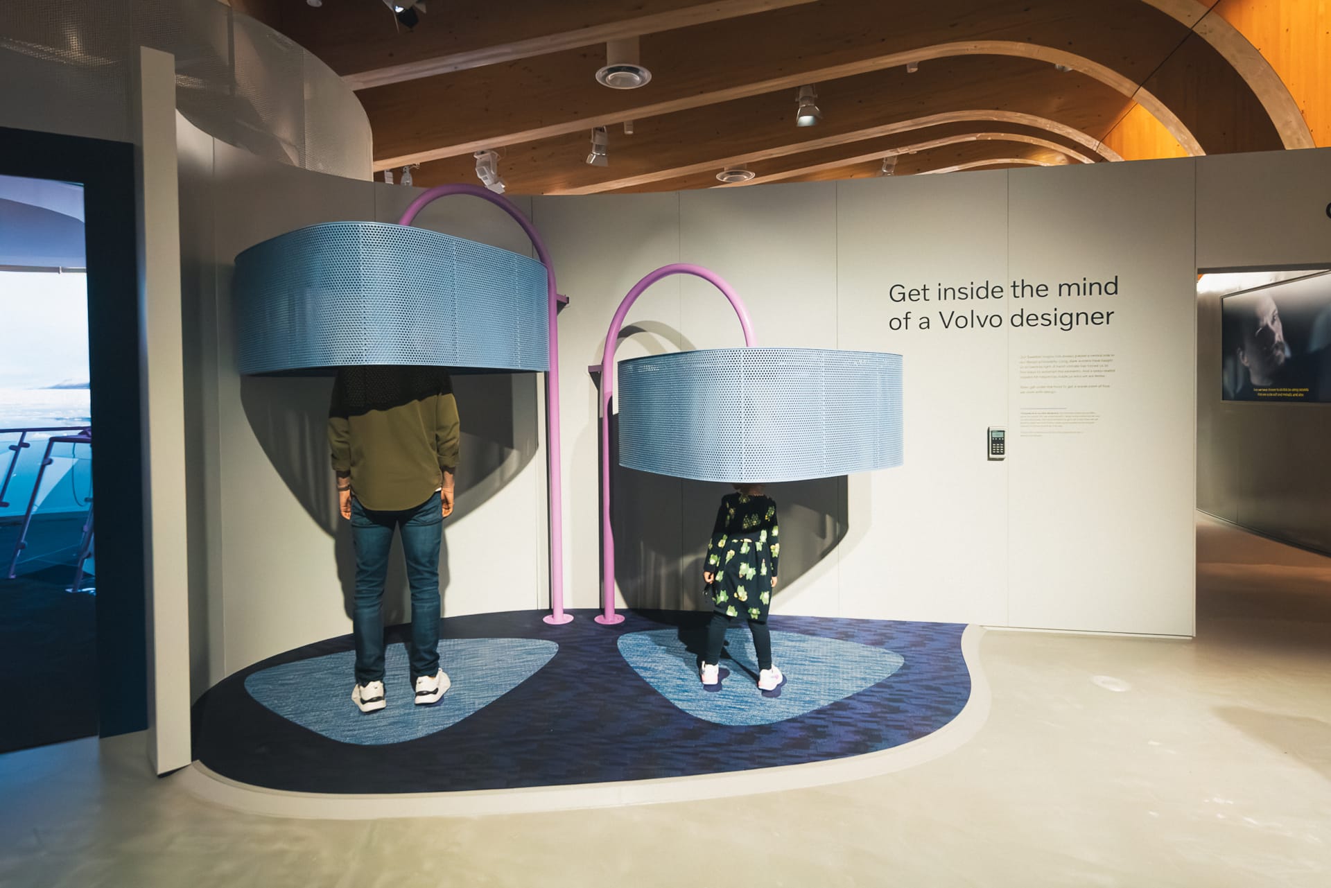Två besökare, en man och ett barn, i en interaktiv installation på utställningen World of Volvo. 