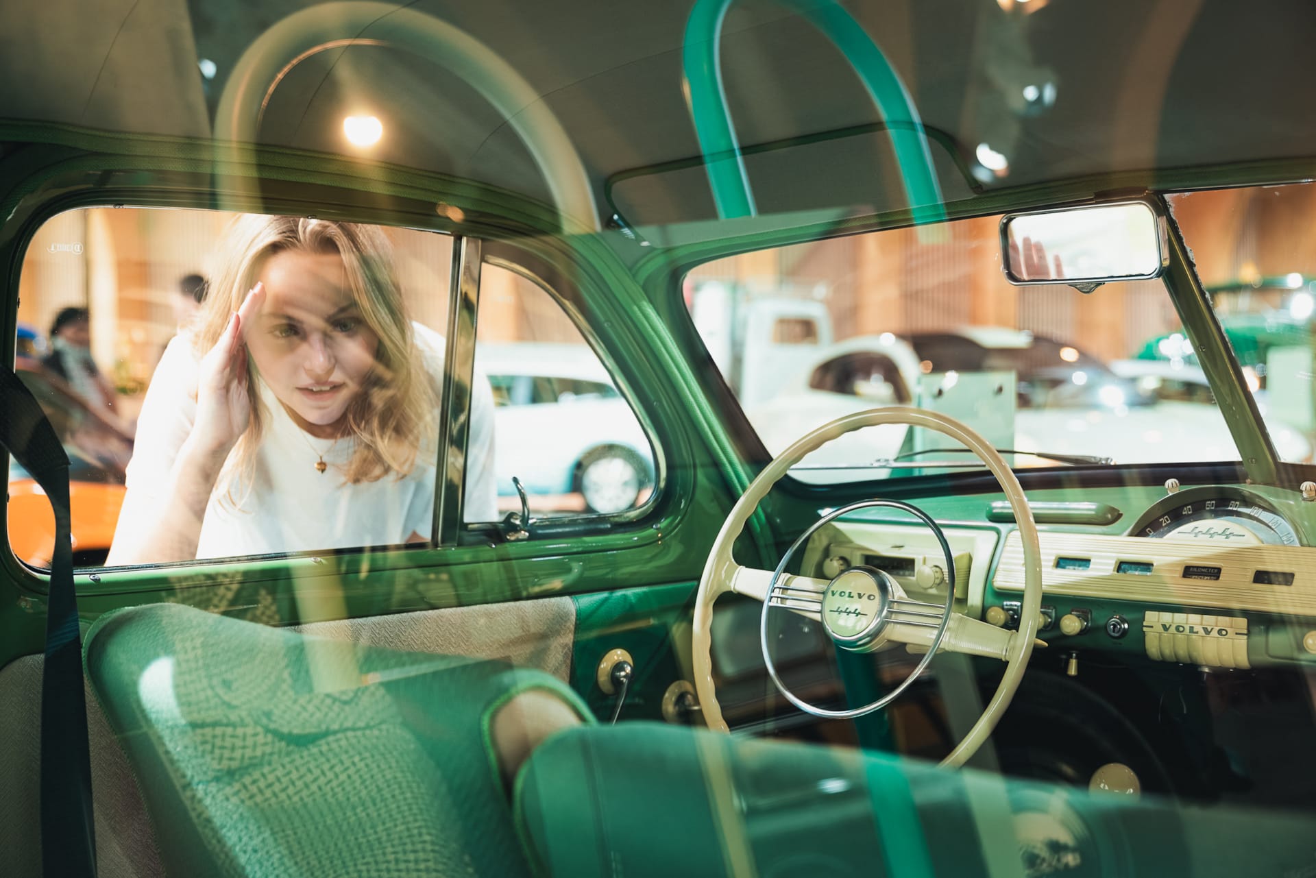 A visitor looking through the window of a volvo car. 